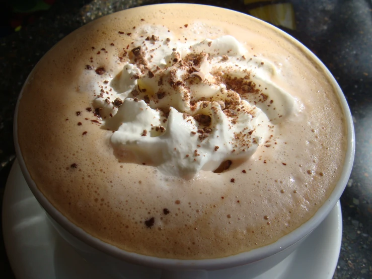 a mug filled with cream and chocolate on top of a plate