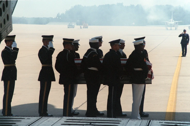 the military guards are waiting on a tarmac