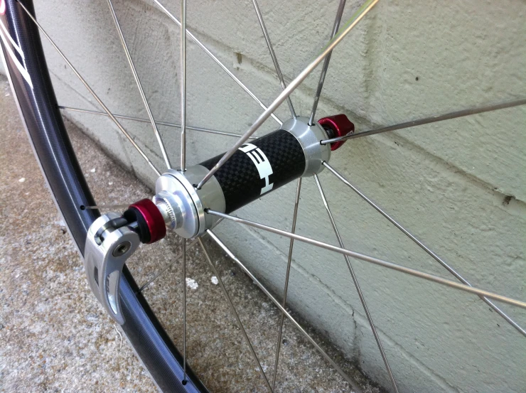 the front wheel of a bicycle leaning against the wall