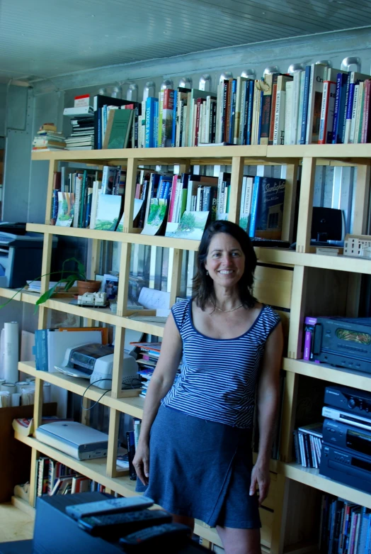 a woman standing in front of book shelves filled with books