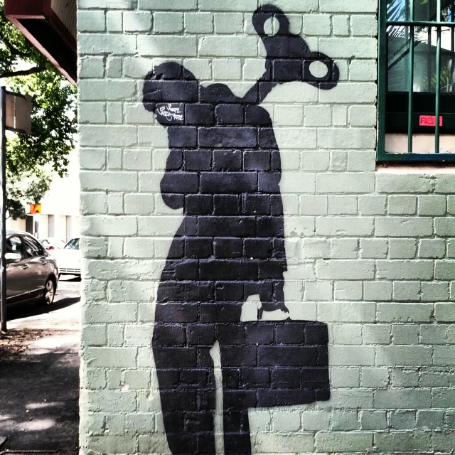 a graffiti of a man holding a bag with the shadow of a person on it