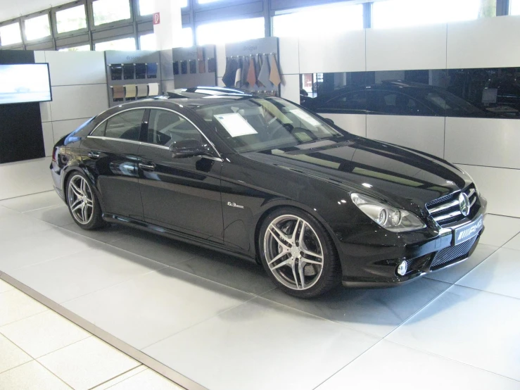 a mercedes with black and chrome rims in a showroom
