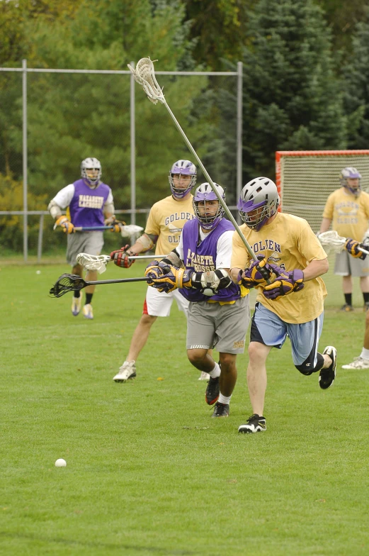 a group of people are playing lacrosse on a field