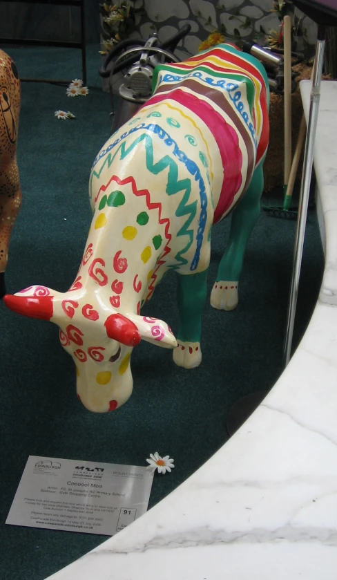 ceramic colorful cow in a display of art