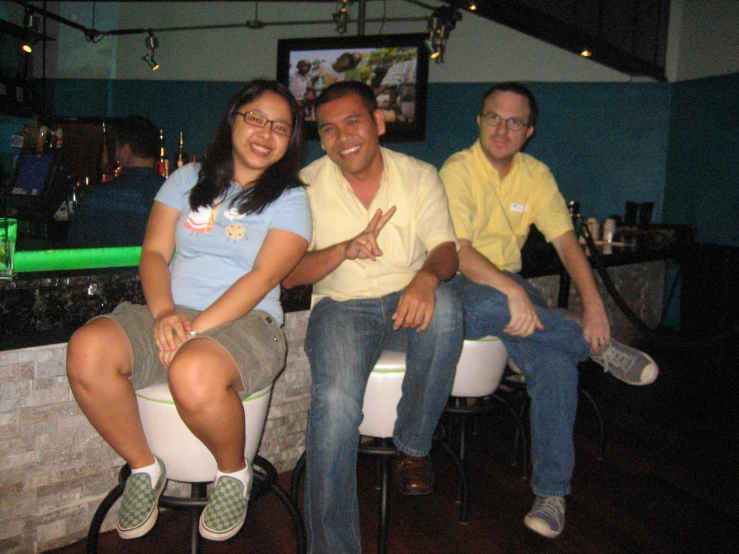 three friends pose for a po together at a bar
