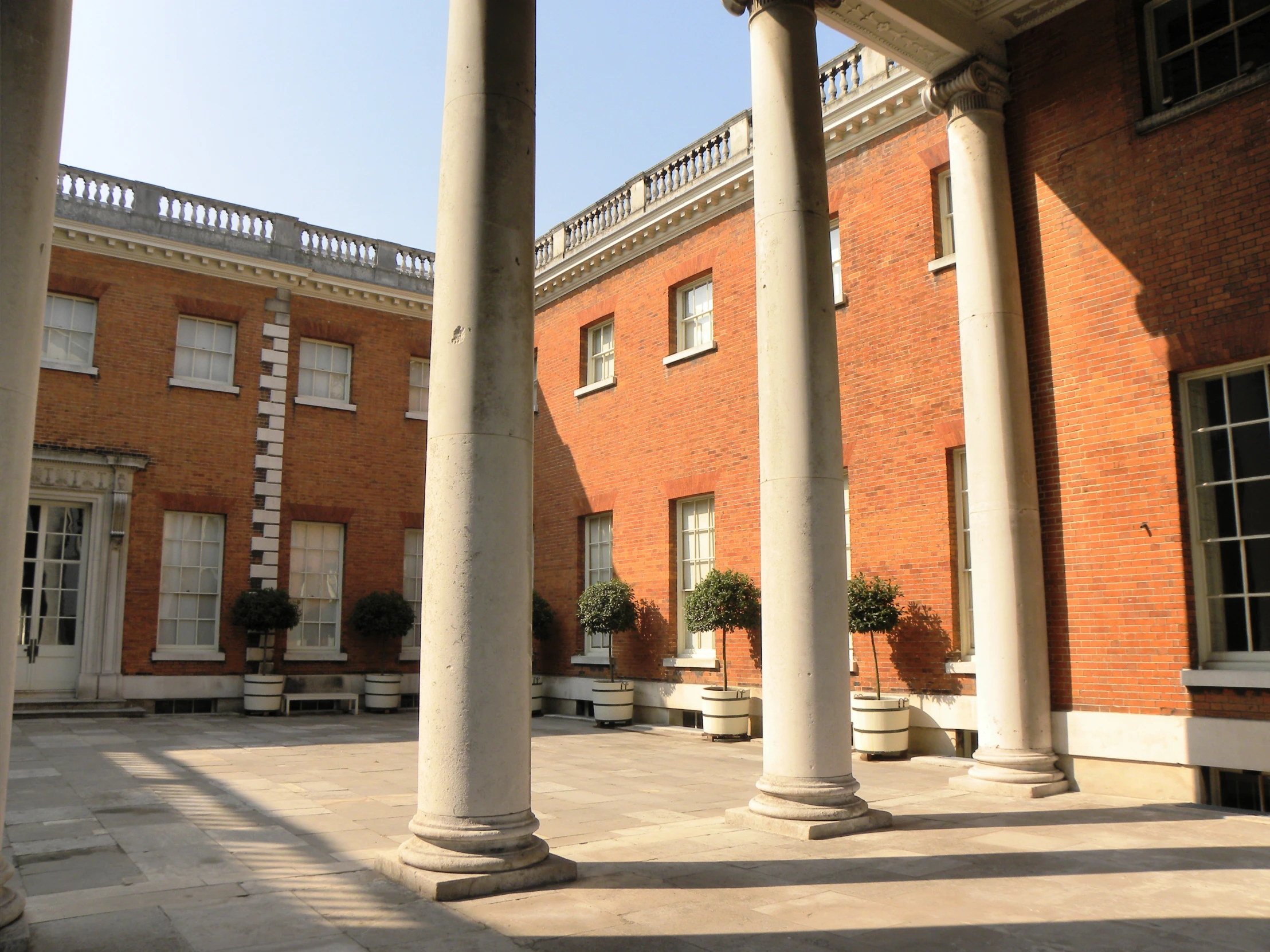 several pillars in front of brick buildings with white pillars on each