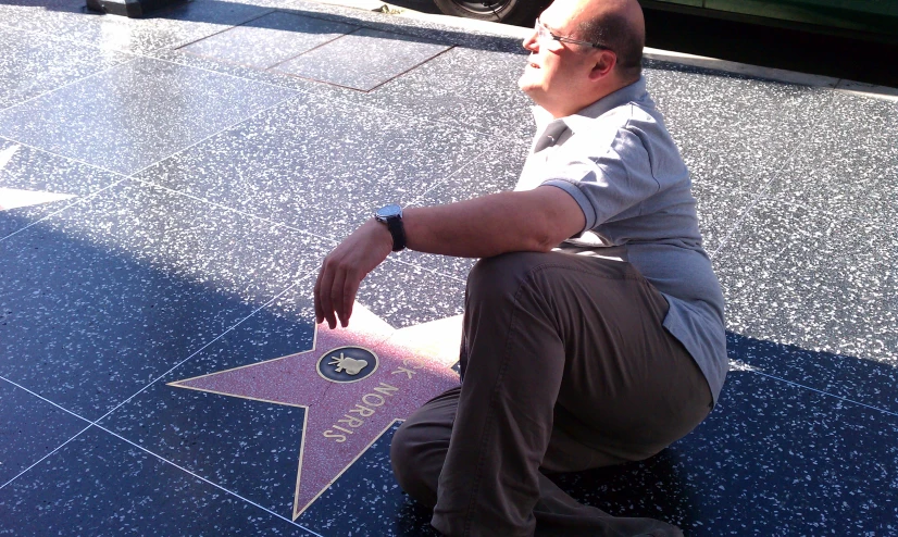 a man is kneeling down near the hollywood star