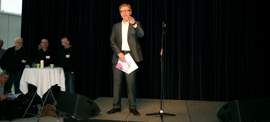 a man standing on a stage with microphone