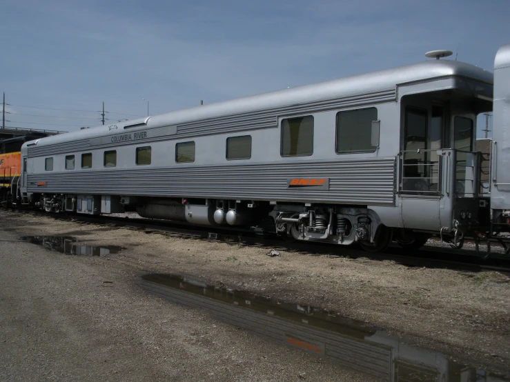 a silver train sits on the tracks by itself