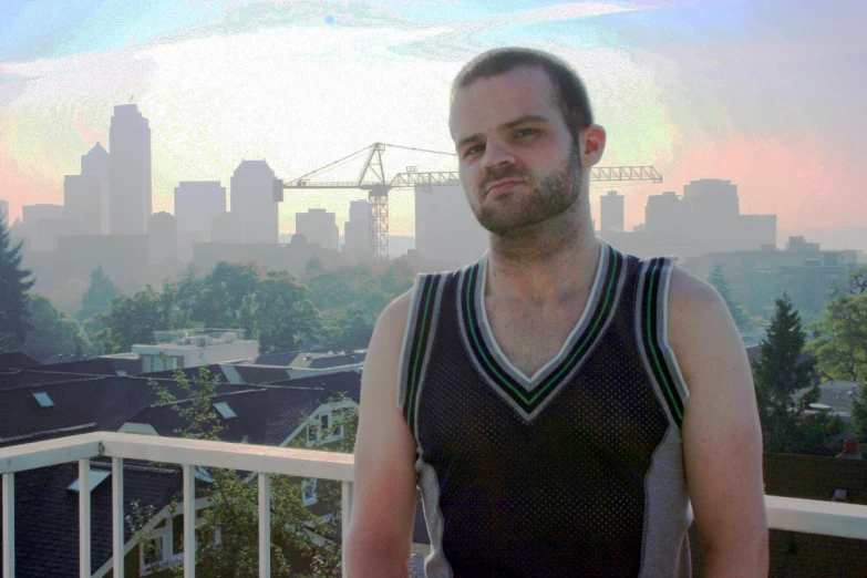there is a man with beard wearing a tank top and looking off into the distance