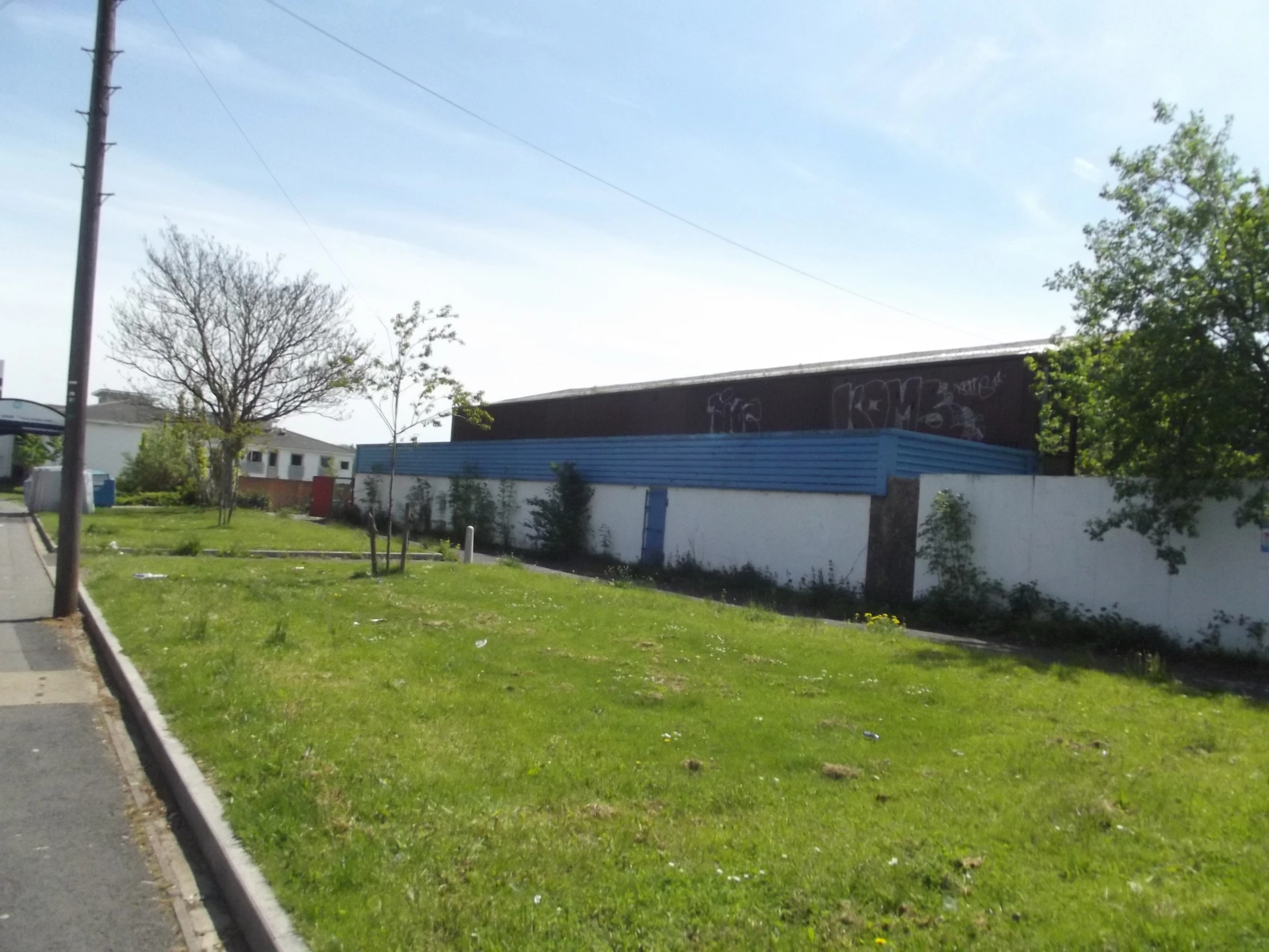 an empty field next to a wall and road