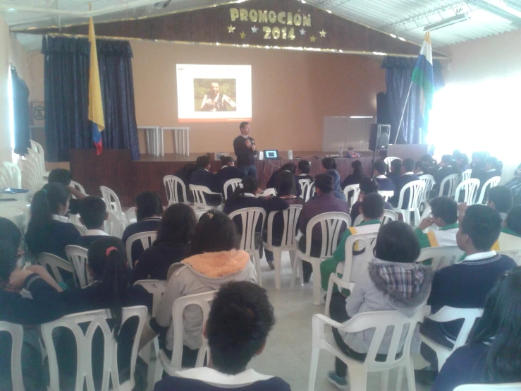 people at chairs in front of a man giving a presentation