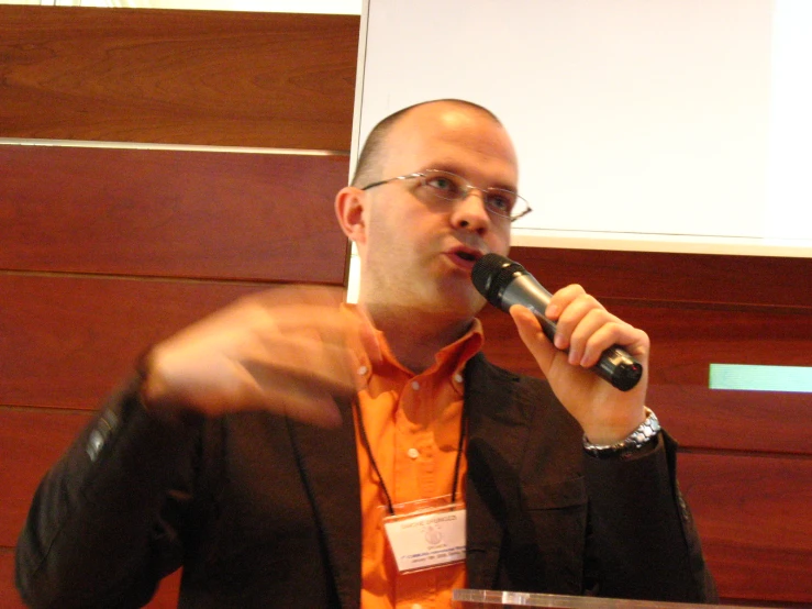 man speaking at the conference with his thumb up