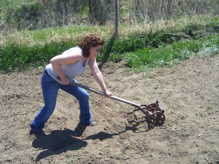 a woman holding a pole while standing in the sand