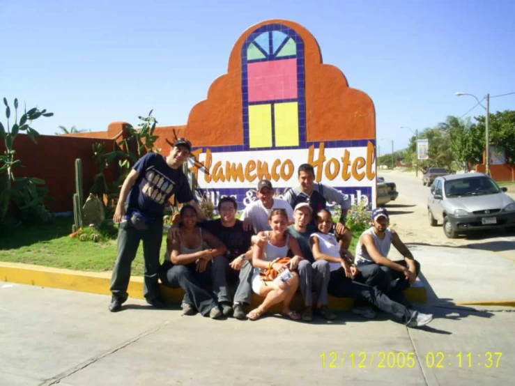a group of people posing for a po in front of the sign