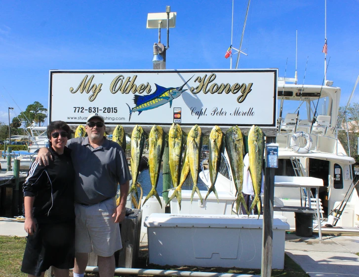 there is a man and woman in front of the fish sign