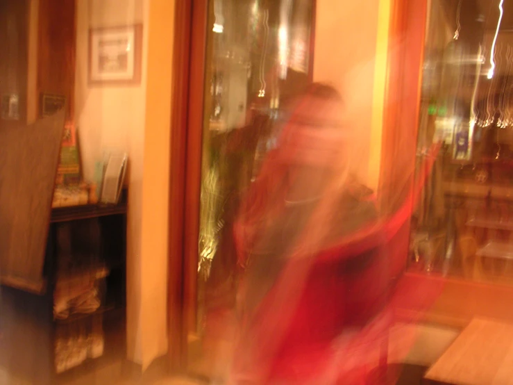 blurry picture of a person sitting at a wooden table