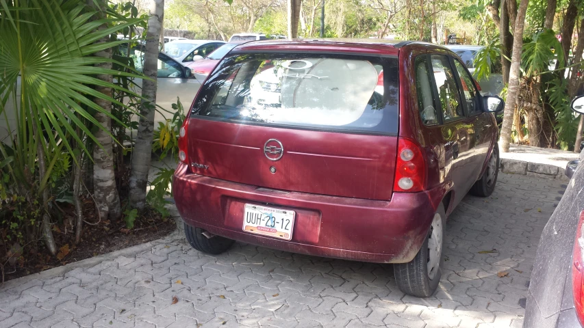 there is a small red car parked on the side of the street