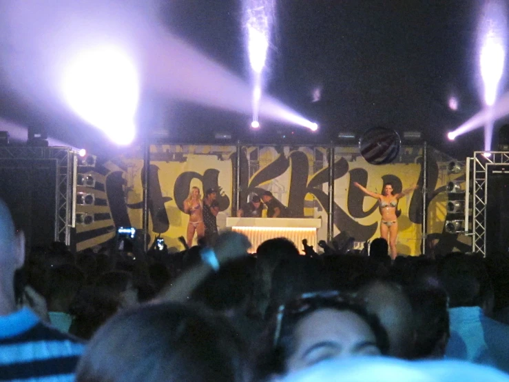 two girls wearing bathing suits singing at a music festival