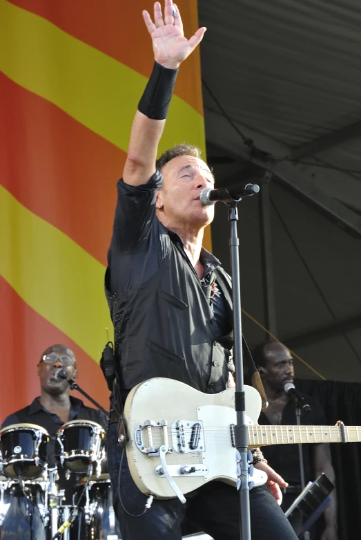 an image of a man that is on stage with a guitar