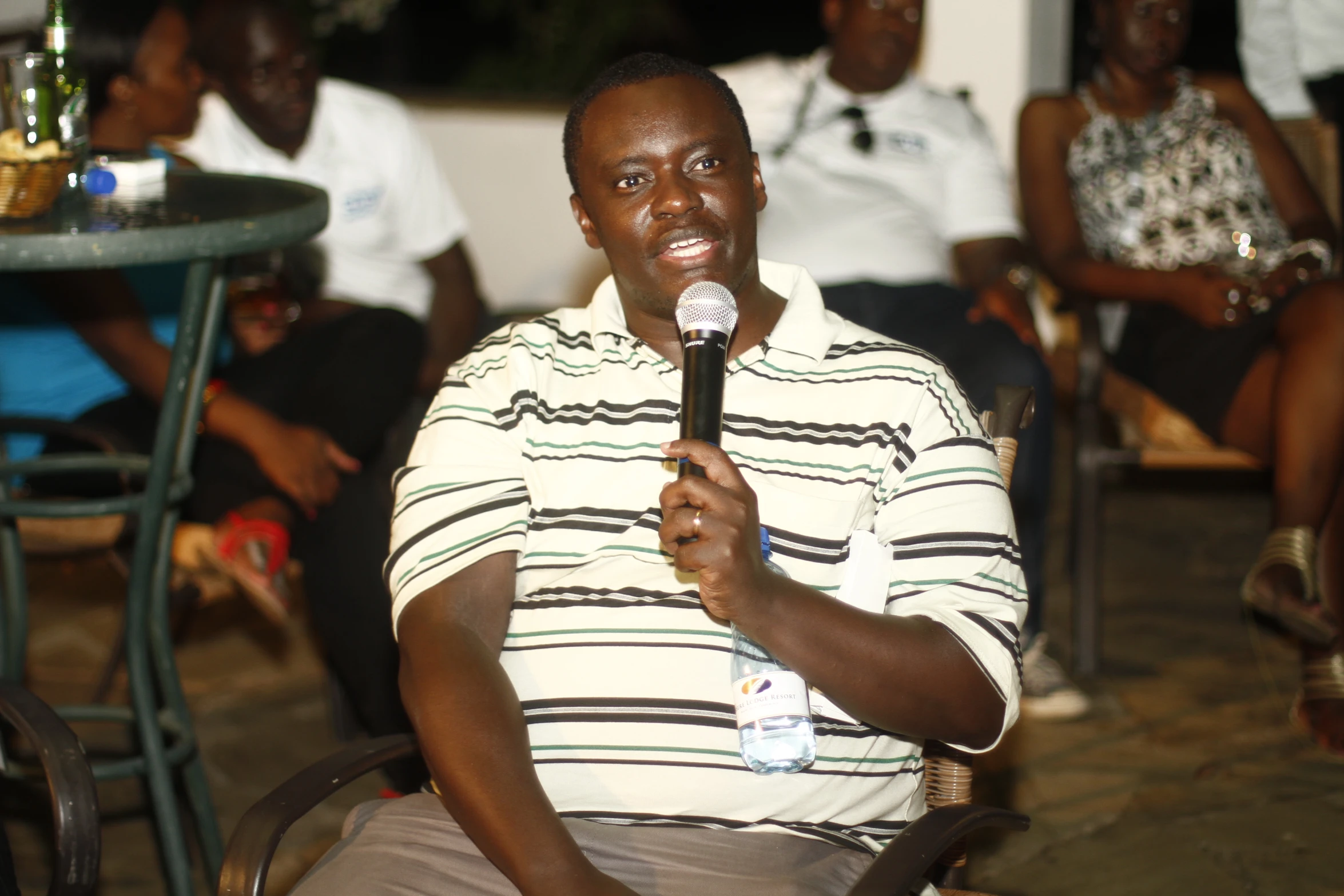 a man in striped shirt holding a microphone