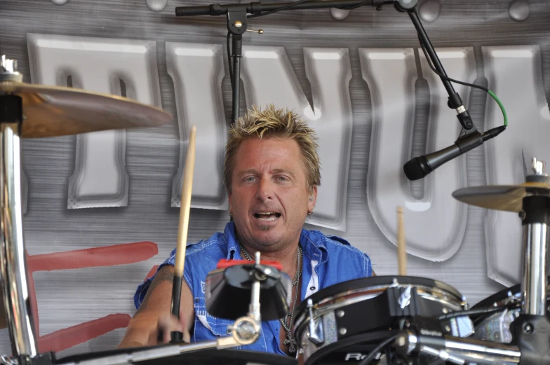 a man with his mouth open, playing the drums