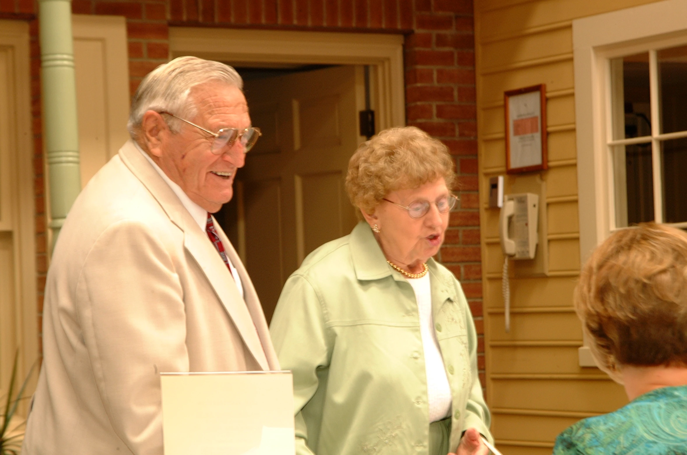 an older couple is standing outside talking to a younger woman