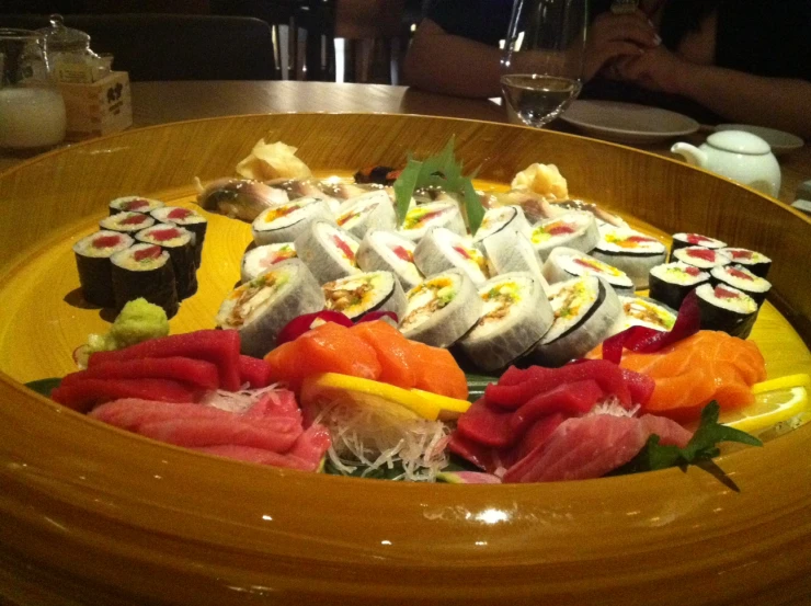 a variety of sushi in a brown bowl on a table
