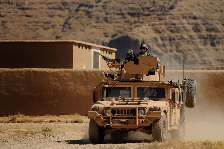 an armored vehicle moving through a dusty desert