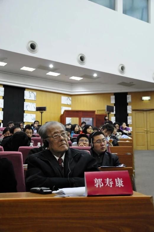 a group of people sitting around each other in a conference room