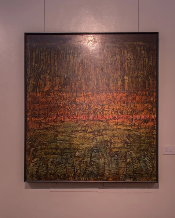 a large brown and orange piece of artwork hanging in a room