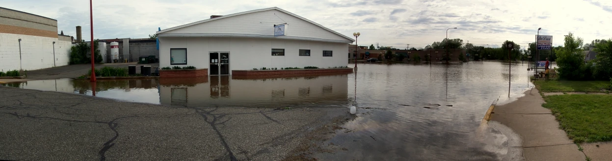 a flooded street with buildings in it and a clock tower