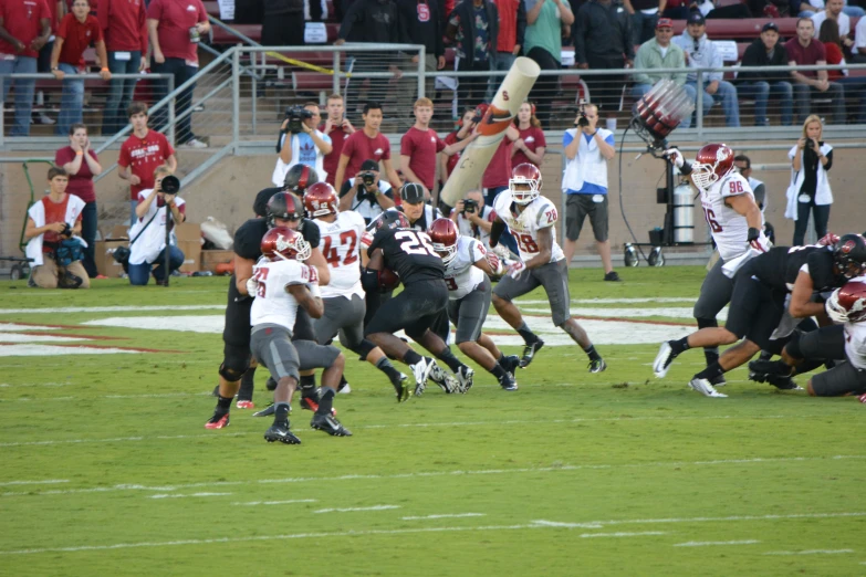 several football players playing on a field with fans in the stands