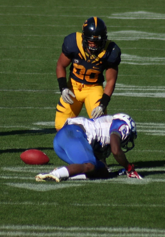 a football player with his feet on the ground near another football player