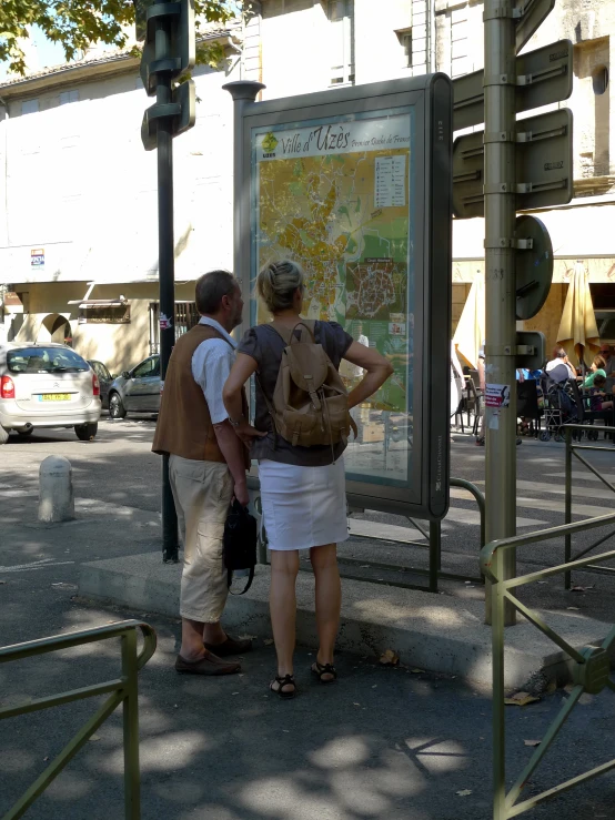 two people looking at a map at the street corner