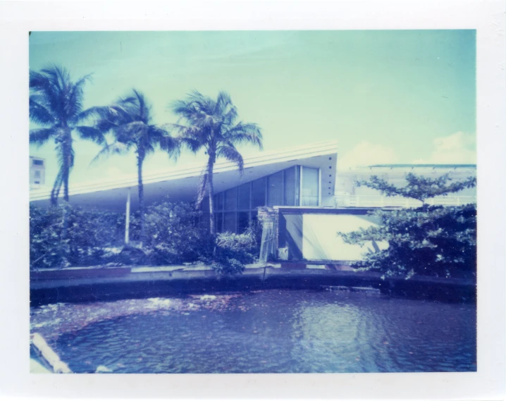 a very modern building with a pool in front