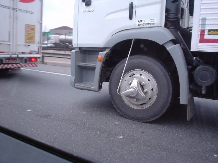 two white trucks are in traffic near each other