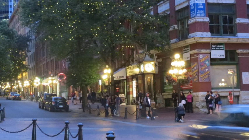 a city street at night with people walking and lights on