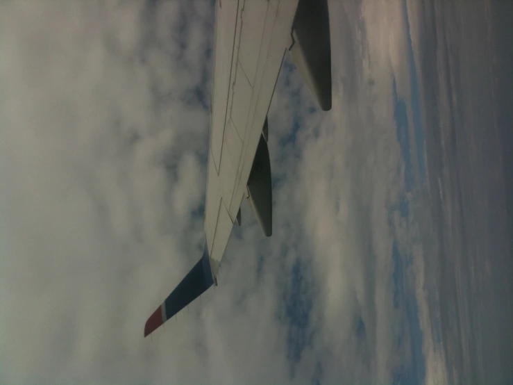 a large jetliner flying through a cloudy blue sky