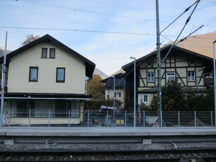 two houses sit side by side on railroad tracks