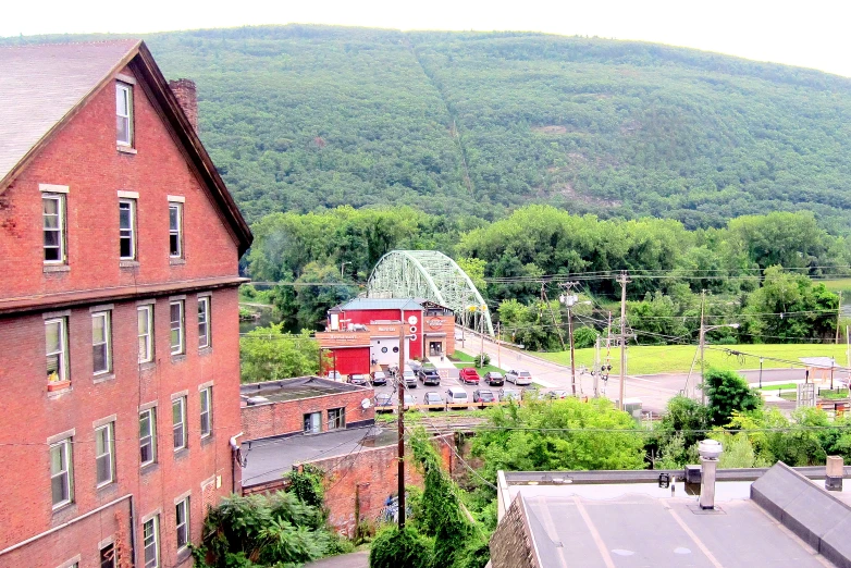 a large red brick building sitting on top of a lush green hillside