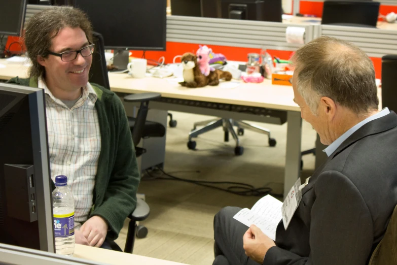 two business men are talking inside of an office