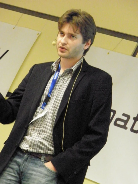 a man in glasses and a tie speaks on stage