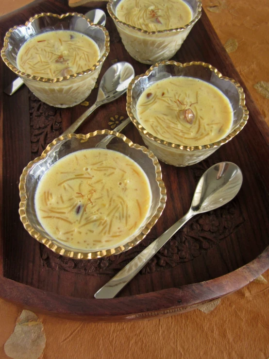 several spoons sit in front of some soup on a plate