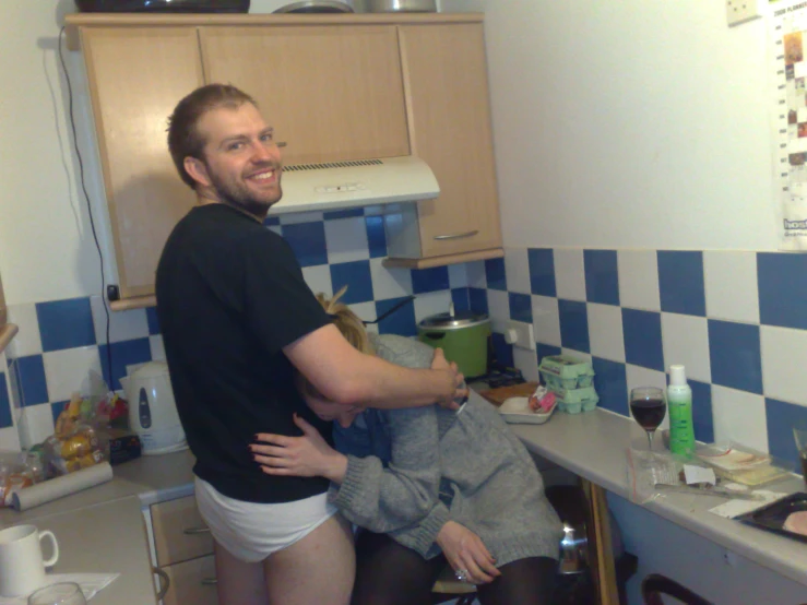 two people are sitting at the kitchen counter