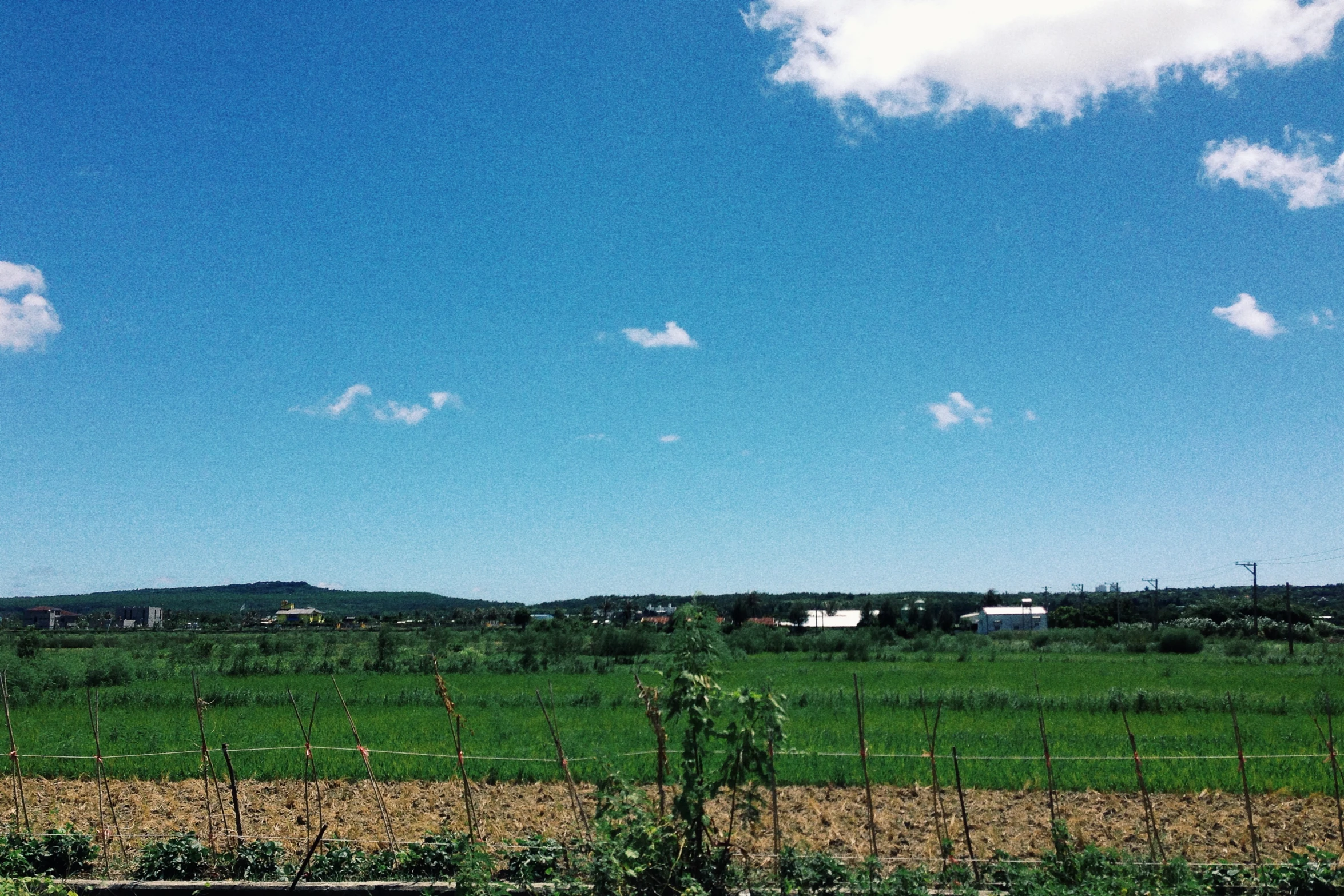 a blue sky with white clouds and farm land