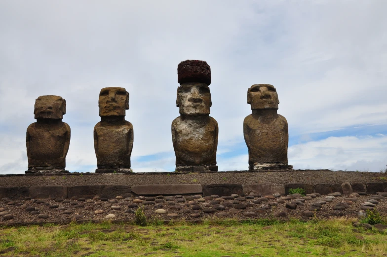 a group of stone statues sitting on top of a hillside