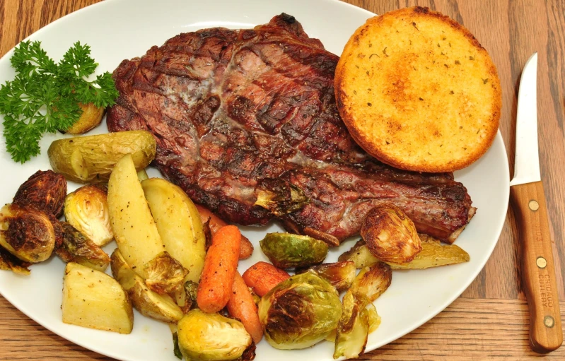 a plate with corned beef, potato and carrots on it