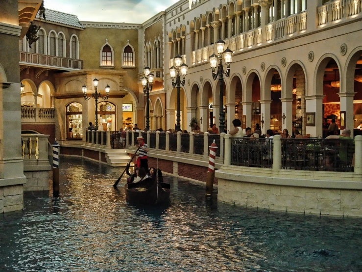 a gondola being ride down a canal in a mall