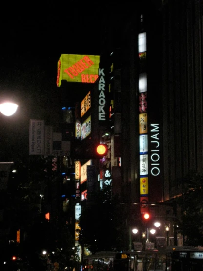 a city intersection at night time with signs on buildings